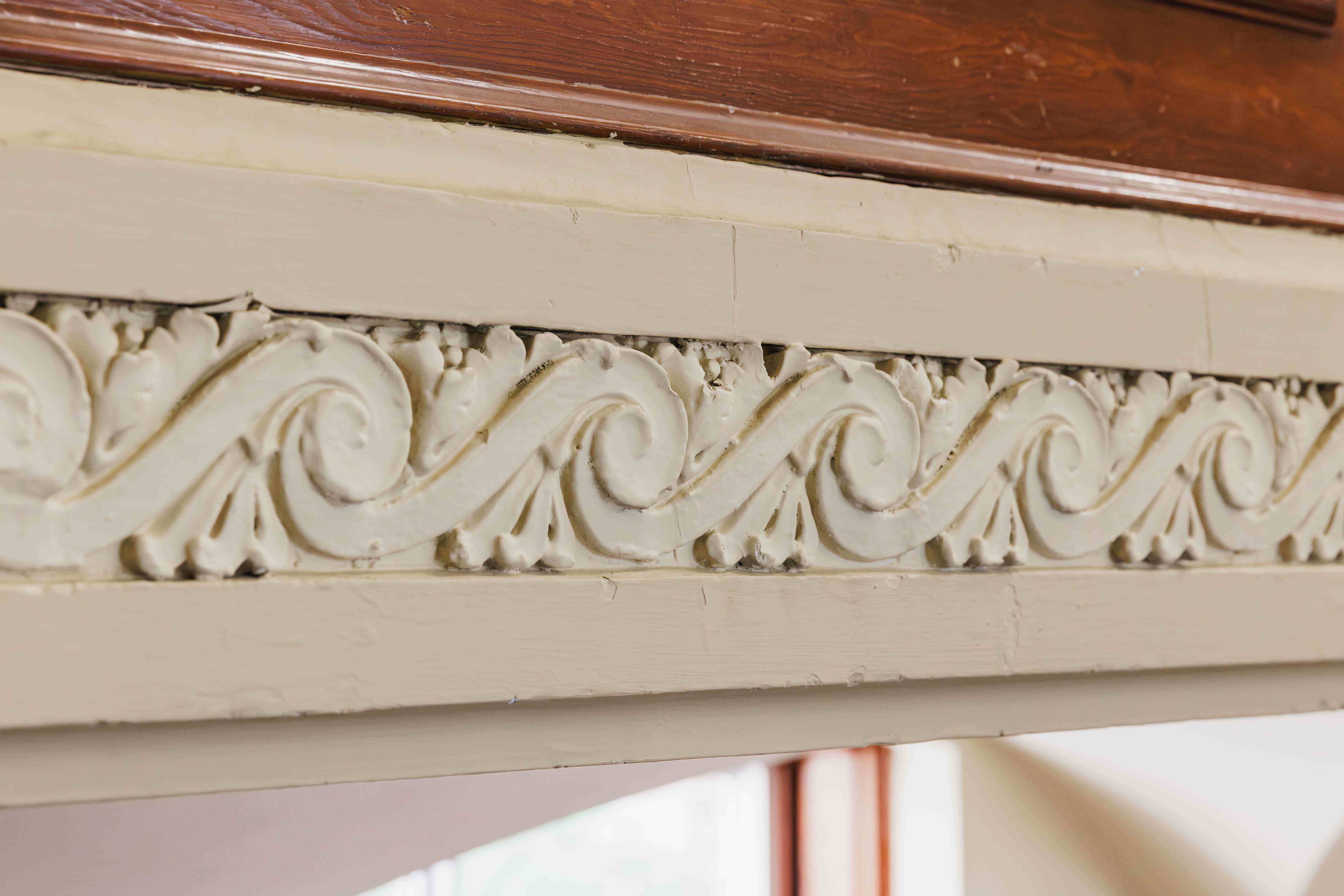 Close-up of decorative plaster moulding with scrollwork detailing inside Convocation Hall at the University of Alberta.